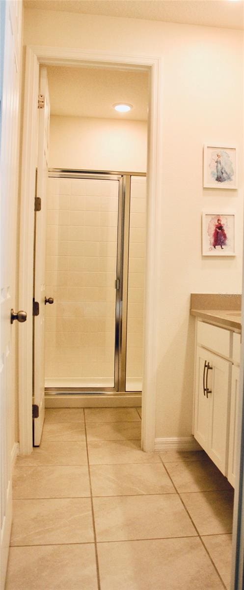 bathroom with a shower with door and tile patterned floors