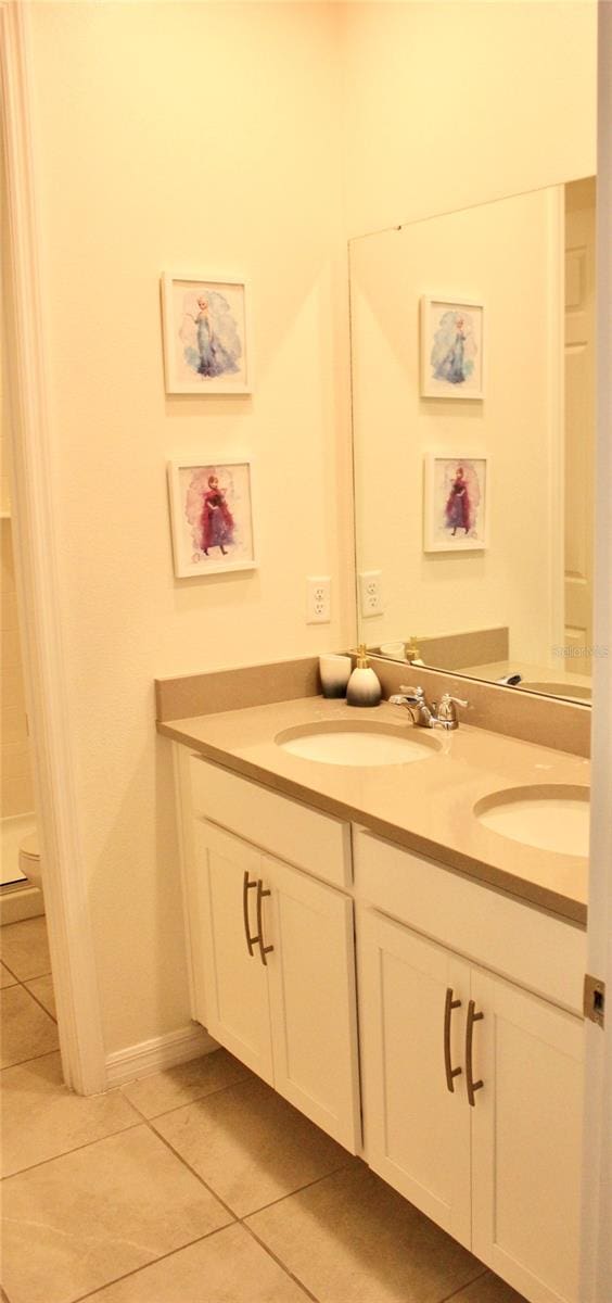 bathroom with tile patterned floors and dual bowl vanity