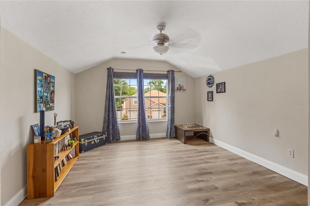 miscellaneous room with lofted ceiling, a textured ceiling, light hardwood / wood-style flooring, and ceiling fan