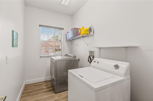 washroom featuring washing machine and dryer and light hardwood / wood-style flooring