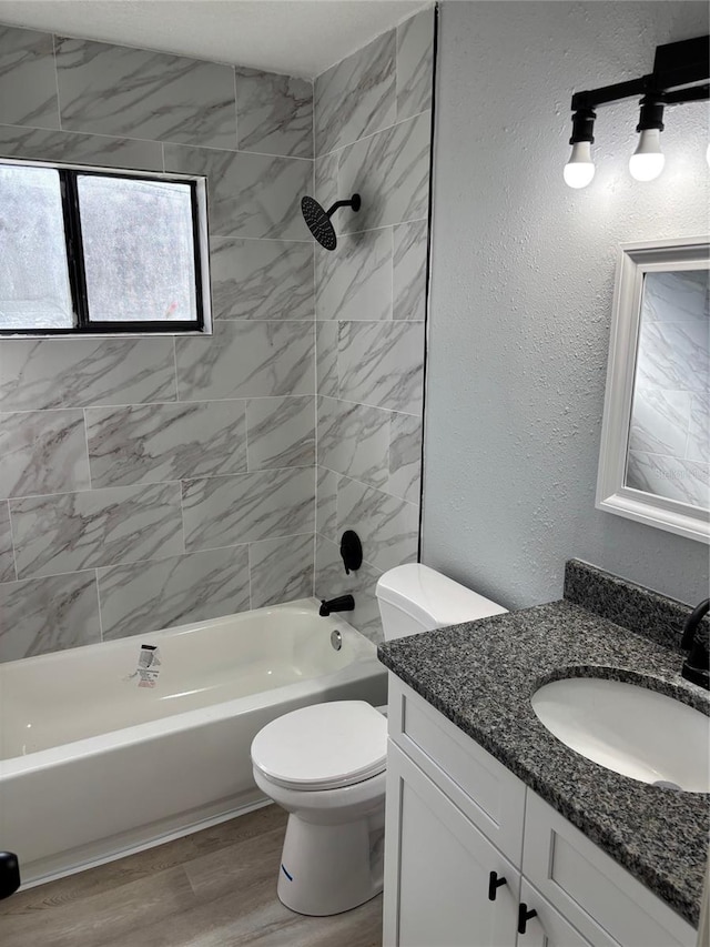 full bathroom featuring vanity, toilet, hardwood / wood-style floors, and tiled shower / bath