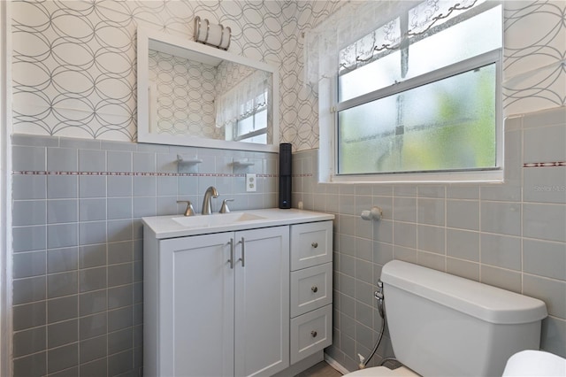 bathroom featuring tile walls, vanity, and toilet