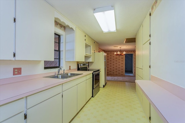 kitchen featuring hanging light fixtures, sink, stainless steel electric range, and white cabinets