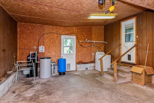 garage with wood walls and washer / dryer