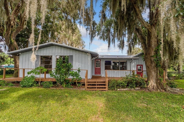 back of property with a yard and a deck