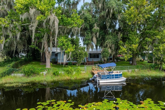 view of dock featuring a water view and a yard