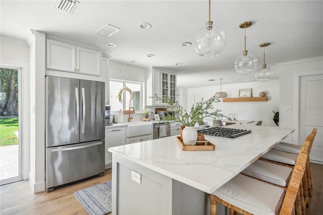 kitchen with a kitchen breakfast bar, stainless steel appliances, and a wealth of natural light