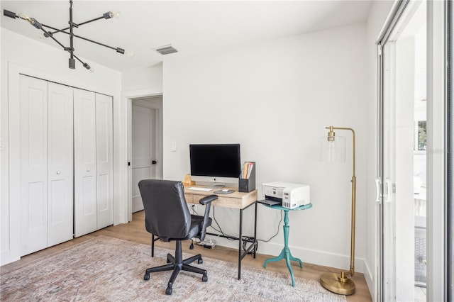 office space featuring light hardwood / wood-style floors and a notable chandelier