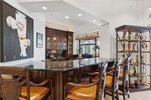 bar featuring crown molding, indoor wet bar, and recessed lighting