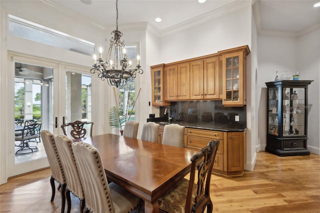 dining room featuring ornamental molding, recessed lighting, light wood-style flooring, and baseboards