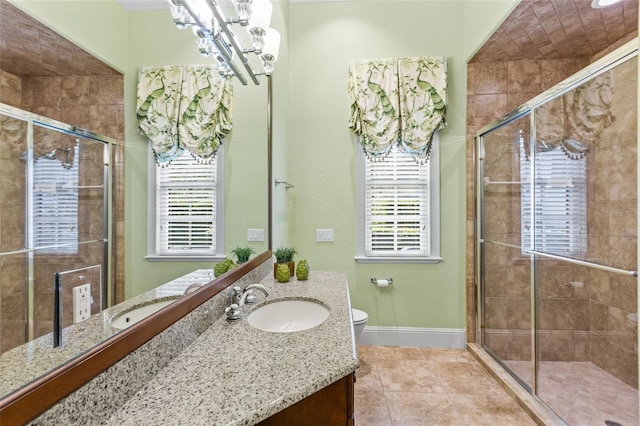 full bath featuring toilet, a notable chandelier, vanity, baseboards, and a shower stall