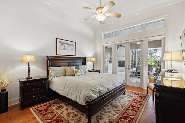 bedroom featuring access to outside, french doors, crown molding, light wood-type flooring, and baseboards