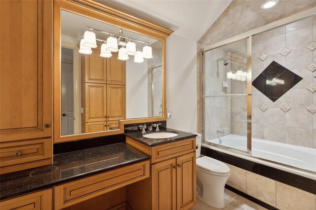 full bathroom with toilet, tile patterned flooring, tiled shower / bath, vaulted ceiling, and vanity