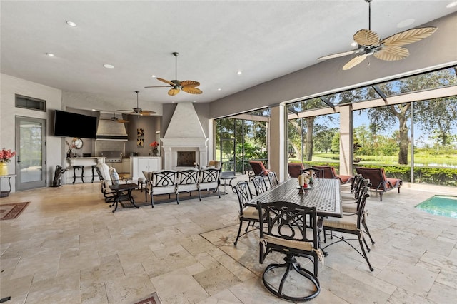 dining space with a sunroom, stone tile floors, and recessed lighting