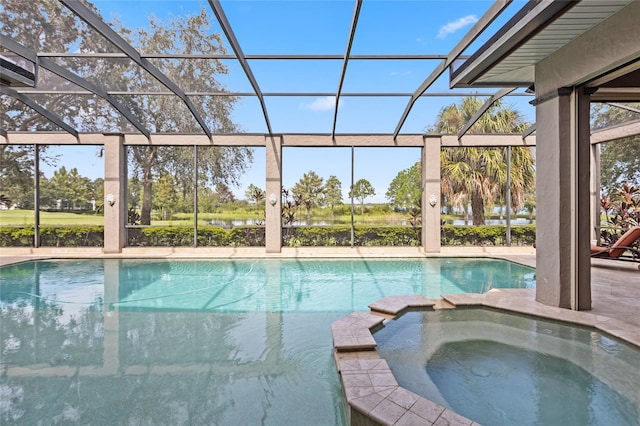 view of pool featuring glass enclosure, a pool with connected hot tub, and a patio