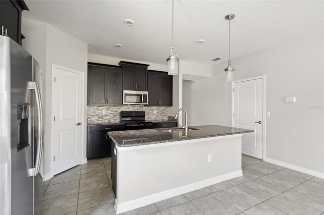 kitchen with sink, an island with sink, hanging light fixtures, and appliances with stainless steel finishes