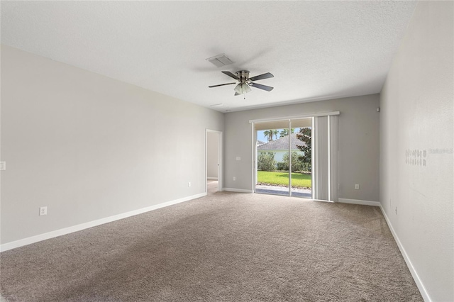 carpeted empty room featuring ceiling fan and a textured ceiling