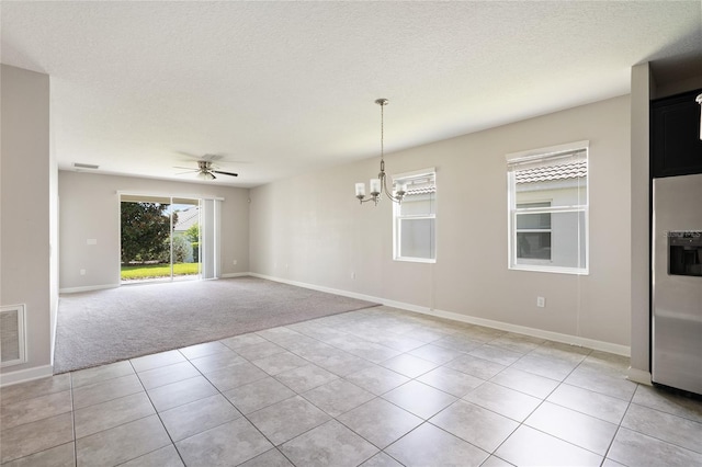 carpeted spare room with a textured ceiling and ceiling fan with notable chandelier