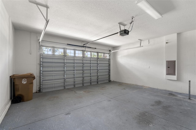 garage featuring concrete block wall, electric panel, and a garage door opener