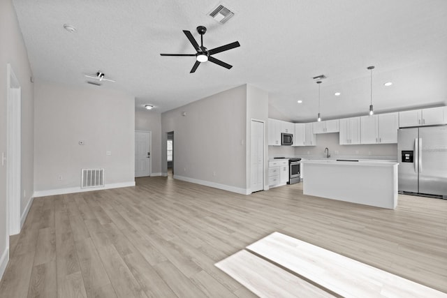 unfurnished living room featuring light hardwood / wood-style floors, sink, a textured ceiling, and ceiling fan