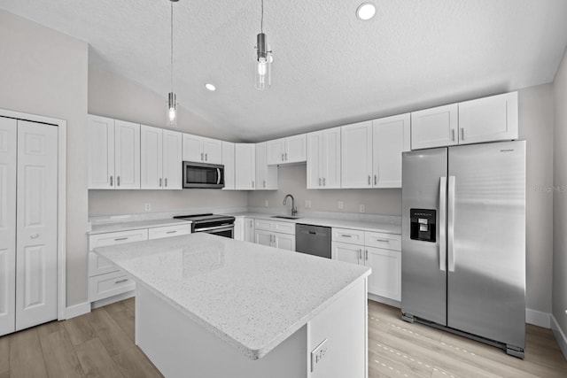 kitchen featuring white cabinetry, stainless steel appliances, light hardwood / wood-style floors, and lofted ceiling