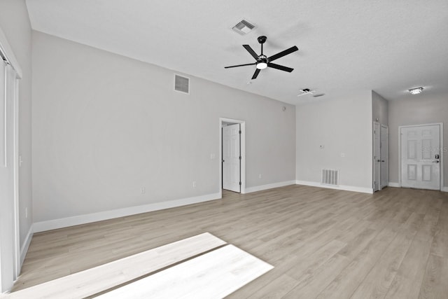 empty room with light hardwood / wood-style floors, a textured ceiling, and ceiling fan