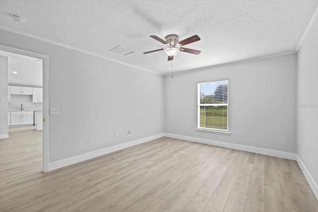 empty room with light hardwood / wood-style flooring, a textured ceiling, ceiling fan, and crown molding