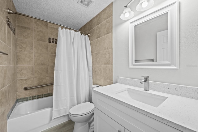 full bathroom featuring shower / bath combo, toilet, vanity, and a textured ceiling