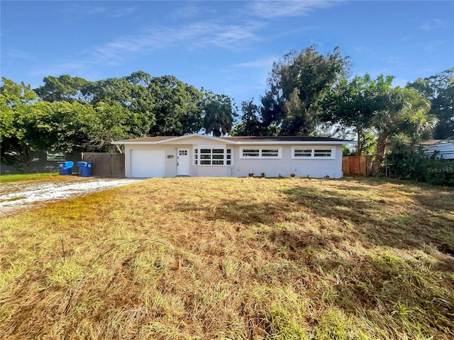 ranch-style home featuring a garage and a front lawn