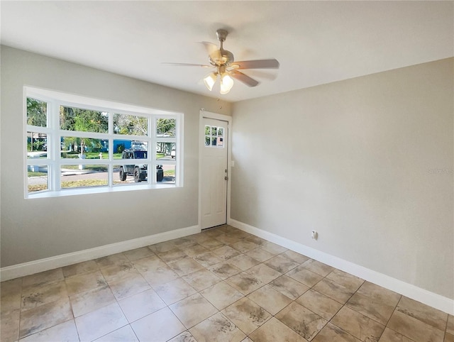 tiled spare room with ceiling fan