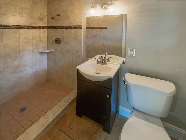 bathroom with tile patterned flooring, toilet, vanity, and a tile shower