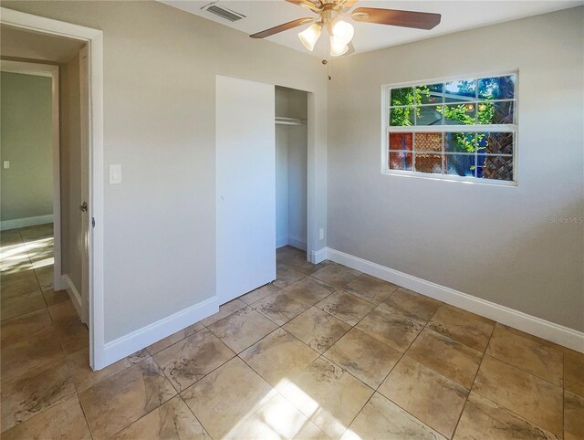 unfurnished bedroom featuring a closet, light tile patterned floors, and ceiling fan