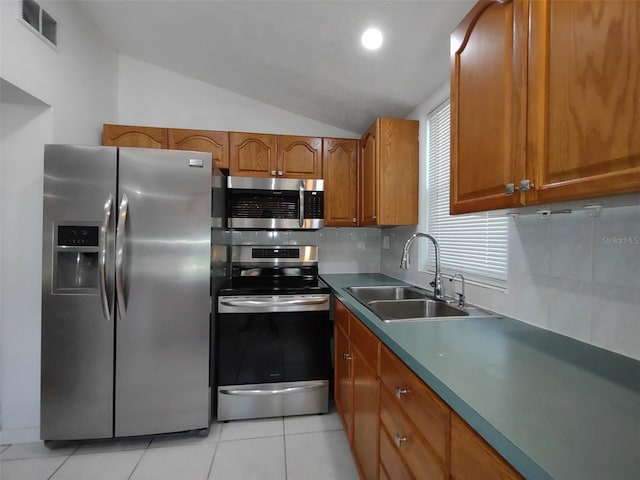 kitchen with tasteful backsplash, stainless steel appliances, sink, lofted ceiling, and light tile patterned floors