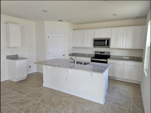 kitchen featuring appliances with stainless steel finishes, a kitchen bar, sink, white cabinets, and a kitchen island with sink