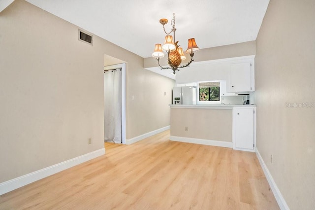 interior space with light hardwood / wood-style floors and an inviting chandelier