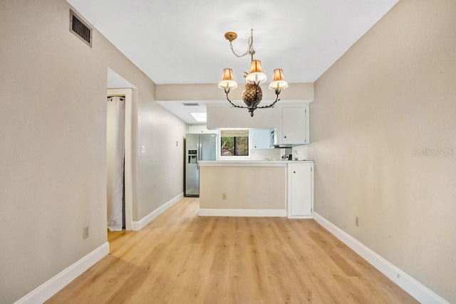 kitchen with light hardwood / wood-style floors, decorative light fixtures, a chandelier, white cabinets, and stainless steel fridge with ice dispenser