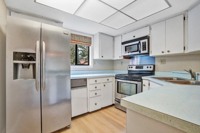 kitchen featuring white cabinetry, appliances with stainless steel finishes, sink, and light hardwood / wood-style floors