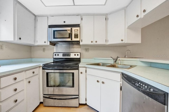 kitchen with light hardwood / wood-style flooring, white cabinets, sink, and stainless steel appliances