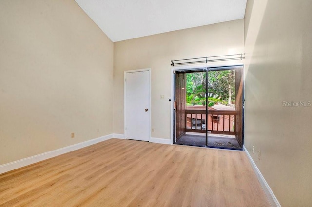 unfurnished room featuring lofted ceiling and light hardwood / wood-style floors