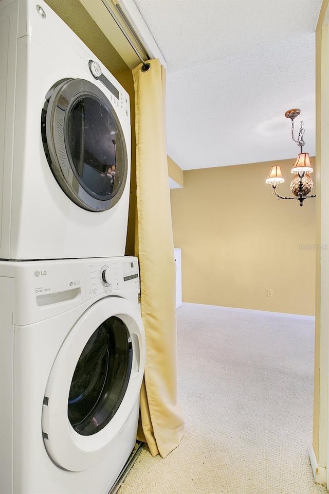 clothes washing area with stacked washer and dryer, a textured ceiling, and carpet flooring