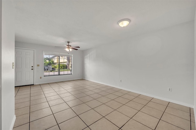 tiled spare room featuring ceiling fan