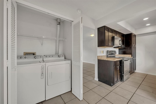 clothes washing area with light tile patterned floors and washer and clothes dryer