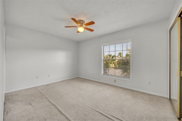 carpeted empty room with a textured ceiling and ceiling fan