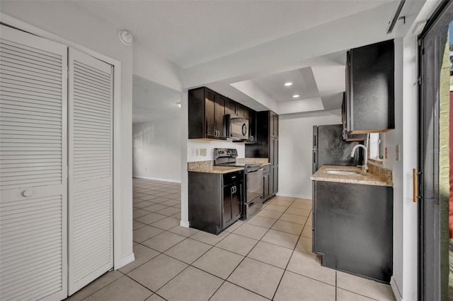 kitchen featuring sink, light tile patterned floors, electric range, dark brown cabinets, and a raised ceiling