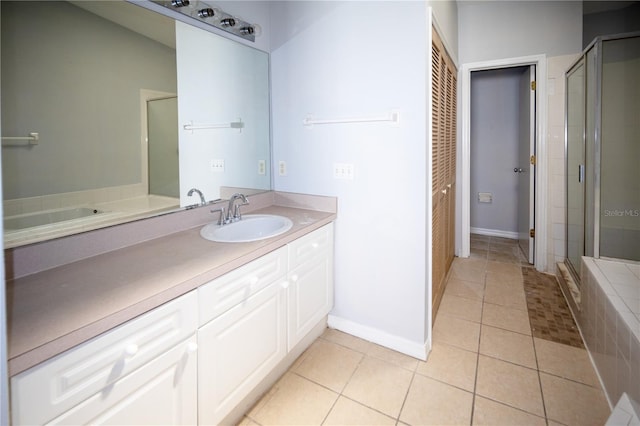 bathroom with walk in shower, vanity, and tile patterned flooring