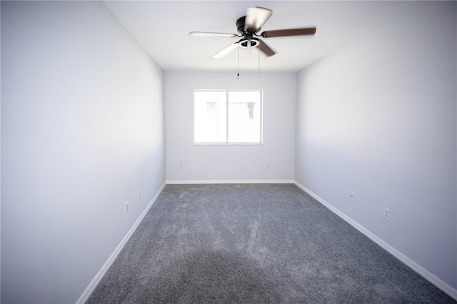 spare room with ceiling fan and dark colored carpet