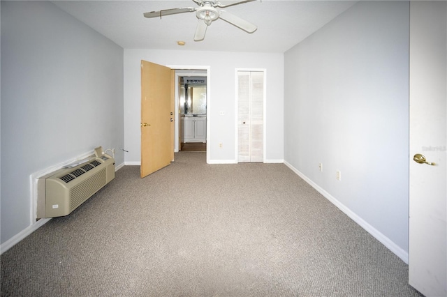 unfurnished bedroom featuring carpet floors, ceiling fan, a wall unit AC, and a closet