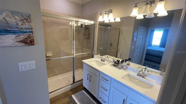 bathroom with hardwood / wood-style flooring, dual vanity, a shower with door, and a notable chandelier