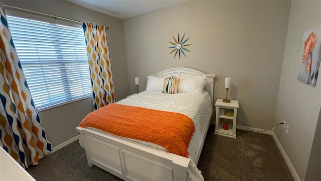 bedroom featuring dark carpet and multiple windows