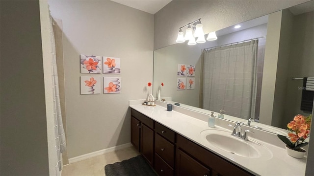 bathroom with tile patterned floors and dual bowl vanity